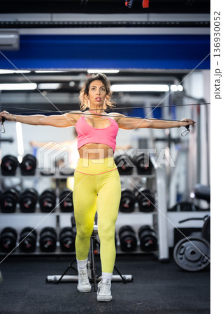 Fit woman training resistance band in modern gym Fit woman training resistance band in modern gym 136930052