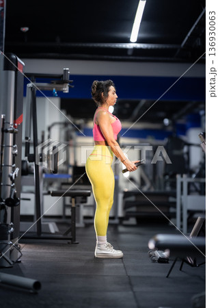 Fit woman training biceps in modern gym Fit woman training biceps in modern gym 136930063