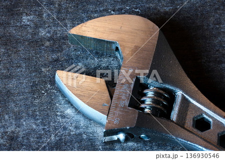 Detailed macro view of an adjustable wrench head showing the screw mechanism and metal texture 136930546