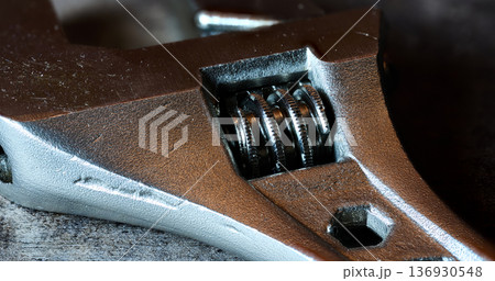 Detailed macro view of an adjustable wrench head showing the screw mechanism and metal texture Detailed macro view of an adjustable wrench head showing the screw mechanism and metal texture 136930548