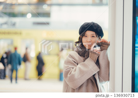 駅構内で歩きながらコーヒーを飲む30代女性 駅構内で歩きながらコーヒーを飲む30代女性 136930713