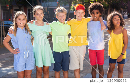Cheerful tween friends standing together on city street Cheerful tween friends standing together on city street 136930931