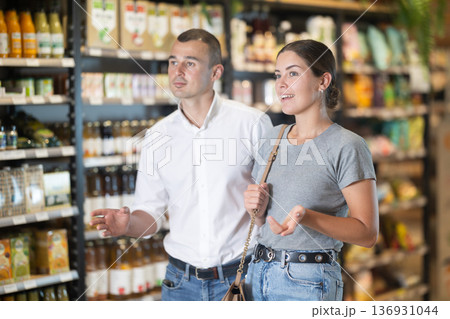 Couple exploring with interest shelves at organic foods store Couple exploring with interest shelves at organic foods store 136931044
