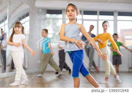 Girl learn to dance modern dances, doing movement with unrecognizable teacher. 136931048