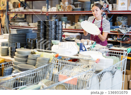 Young woman posing with ceramic dishes 136931070