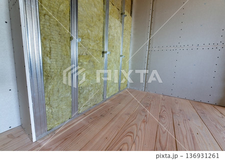 Wall of a room under renovation with mineral rock wool insulation and metal frame prepared for drywall plates. 136931261