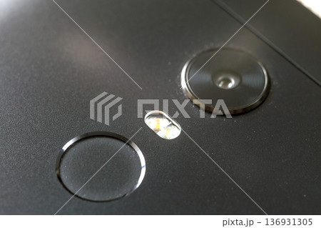 Close-up detail of cellphone with security thumb fingerprint scanning device and camera. Modern technology security and smartphone design concept. 136931305