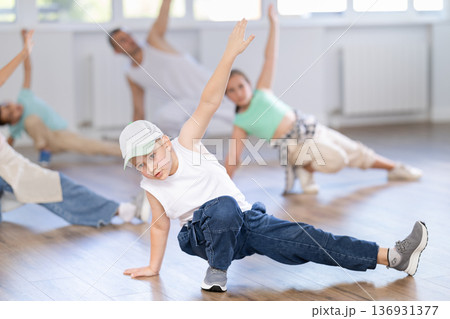 Preteen boys and girls studying movement of contemporary dance in classroom with his friends 136931377