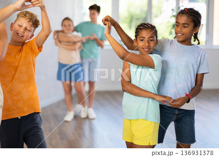 Active preteen children practicing Ballroom dances in pairs in training hall Active preteen children practicing Ballroom dances in pairs in training hall 136931378