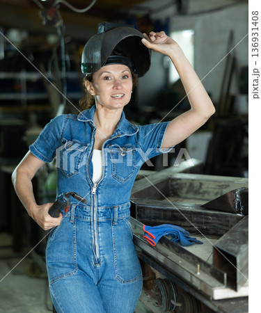 During manufacture of product, woman employee works with welding machine During manufacture of product, woman employee works with welding machine 136931408