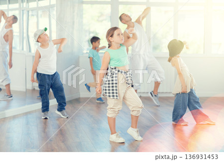 Girls and boys training hip hop in dance studio, dance classes for kids Girls and boys training hip hop in dance studio, dance classes for kids 136931453