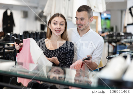 Man with wife participate in inspection of goods, help determine choice of blouse Man with wife participate in inspection of goods, help determine choice of blouse 136931468