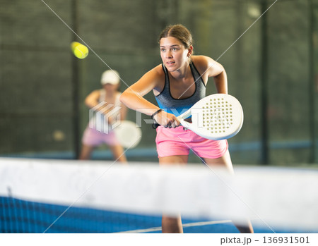Young and adult women playing doubles tennis Young and adult women playing doubles tennis 136931501