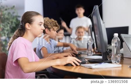 Girl student learning to work on computer in classroom Girl student learning to work on computer in classroom 136931508