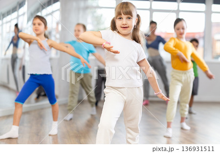 Girl learn to dance modern dances, doing movement with unrecognizable teacher. Girl learn to dance modern dances, doing movement with unrecognizable teacher. 136931511