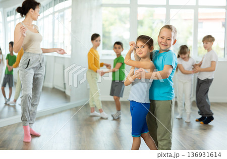 Girl paired up with boy and training to perform slow couple dance, rehearse performance. Girl paired up with boy and training to perform slow couple dance, rehearse performance. 136931614