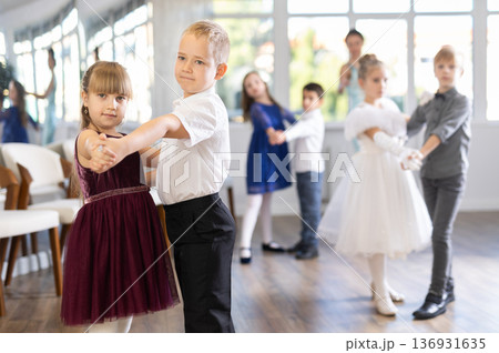 Preteen pupils rehearsing ballroom dance for festive school event Preteen pupils rehearsing ballroom dance for festive school event 136931635
