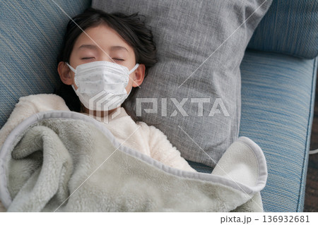 風邪をひいてソファで眠る子供 136932681