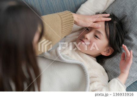 体調の悪い女の子と看病する母親 136933916