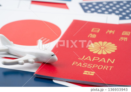 色々な国旗のカードの上の赤い日本のパスポートと飛行機のミニチュア 色々な国旗のカードの上の赤い日本のパスポートと飛行機のミニチュア 136933943