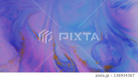 Dye stream blur. Shimmering fluid. Blue paint mixing in color liquid with orange glitter. Neon pigment drop on purple abstract background. 136934367