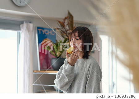 パウンドケーキをつまみ食いする女性 136935290