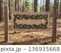 Christmas rustic burlap sign displaying clean pine needles text surrounded by pine branches in a forest setting 136935668