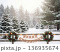 Christmas winter landscape with snowy pine trees and wooden fence decorated with wreaths and banner 136935674