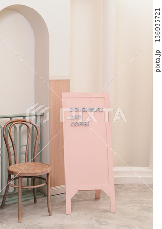 Pink sign doughnut coffee cafe menu pastel interior chair wooden vertical minimal modern shop bakery beverage drink morning breakfast snack treat cozy empty seat retro vintage arch wall floor 136935721