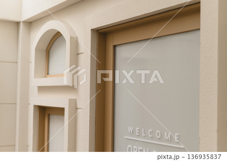 Welcome open door sign glass modern beige entrance minimalist store facade warm neutral color frosted window detail inviting shop exterior urban retail design contemporary architecture style clean 136935837