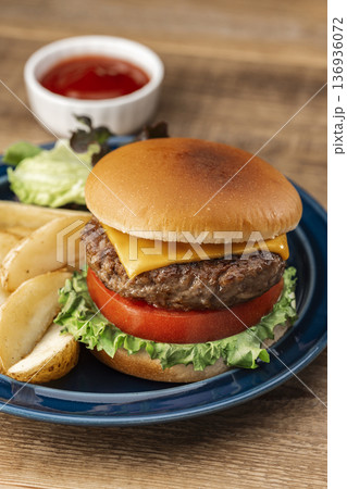 木製テーブルに置かれたハンバーガーとフライドポテトのクローズアップ 木製テーブルに置かれたハンバーガーとフライドポテトのクローズアップ 136936072