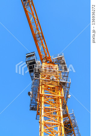 青空を背景にしたタワークレーンの建設現場イメージ 青空を背景にしたタワークレーンの建設現場イメージ 136936272