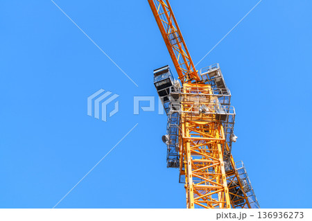 青空を背景にしたタワークレーンの建設現場イメージ 136936273