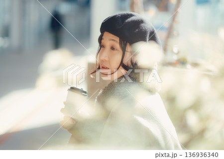 冬の屋外ベンチでコーヒーを楽しむ女性 冬の屋外ベンチでコーヒーを楽しむ女性 136936340
