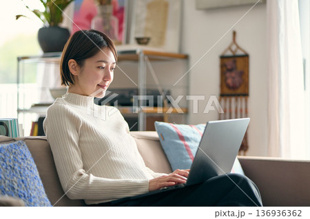 自宅でパソコンを操作する女性 自宅でパソコンを操作する女性 136936362