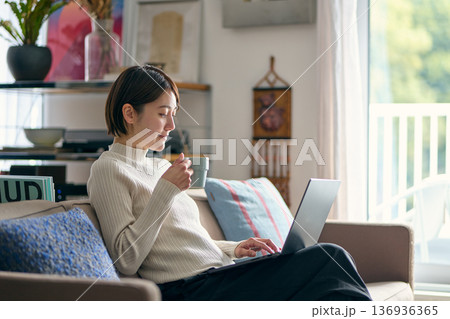 自宅でパソコンを操作する女性 自宅でパソコンを操作する女性 136936365