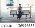 バス停で座ってスマートフォンを見る冬の女性 136936685