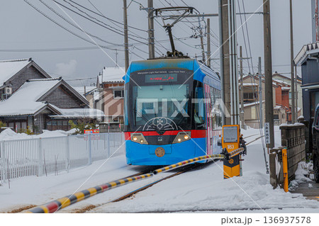 雪景色を走る万葉線のライトレール 136937578