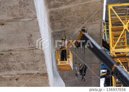 橋梁下で高所作業を行う作業員と高所作業車 136937656