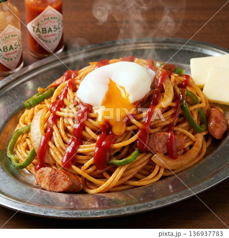 ケチャップをたっぷり使ったイタリアンパスタの上で半熟卵がとろけているシズル感のある様子 136937783