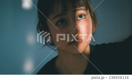 光の射す方を見つめる若い女性 光の射す方を見つめる若い女性 136938118