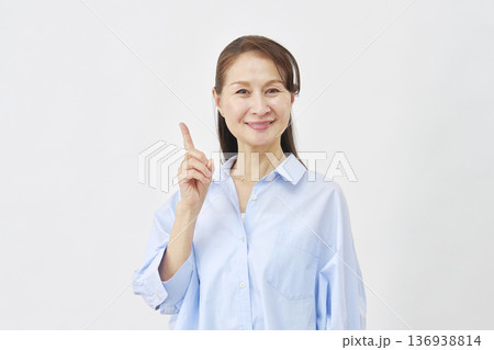 白背景で左側を指差す女性 136938814