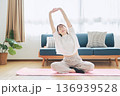 自宅で体をほぐすストレッチをする30代女性の健康習慣 136939528