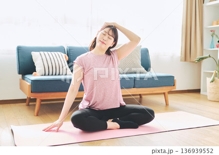 自宅で体をほぐすストレッチをする30代女性の健康習慣 自宅で体をほぐすストレッチをする30代女性の健康習慣 136939552