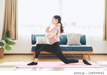 自宅のリビングでヨガポーズをする30代女性のフィットネスライフ 136939562