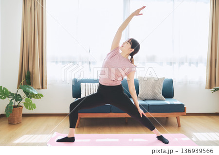自宅のリビングでヨガポーズをする30代女性のフィットネスライフ 自宅のリビングでヨガポーズをする30代女性のフィットネスライフ 136939566