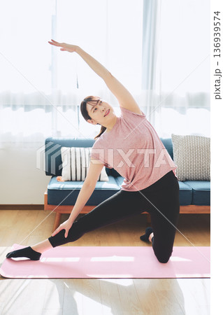 自宅のリビングでヨガポーズをする30代女性のフィットネスライフ 自宅のリビングでヨガポーズをする30代女性のフィットネスライフ 136939574