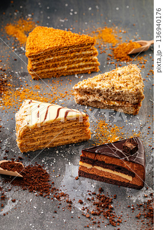Assorted layered cake slices on dark table 136940176