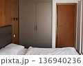 Modern cozy bedroom interior with wardrobe wooden door and soft lighting 136940236