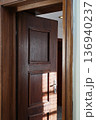 Open wooden interior door with sunlight shadows and warm atmosphere 136940237